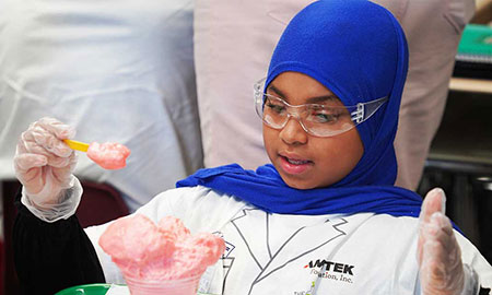 An elementary school student watches her Matter Monster experiment grow in size